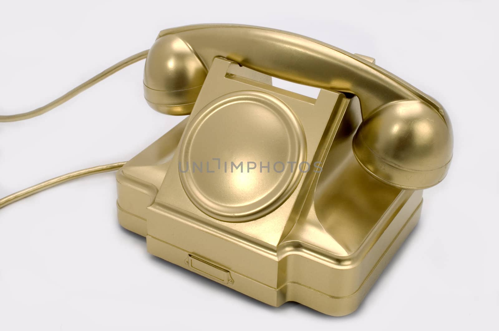 The telephone of gold colour on a white background.