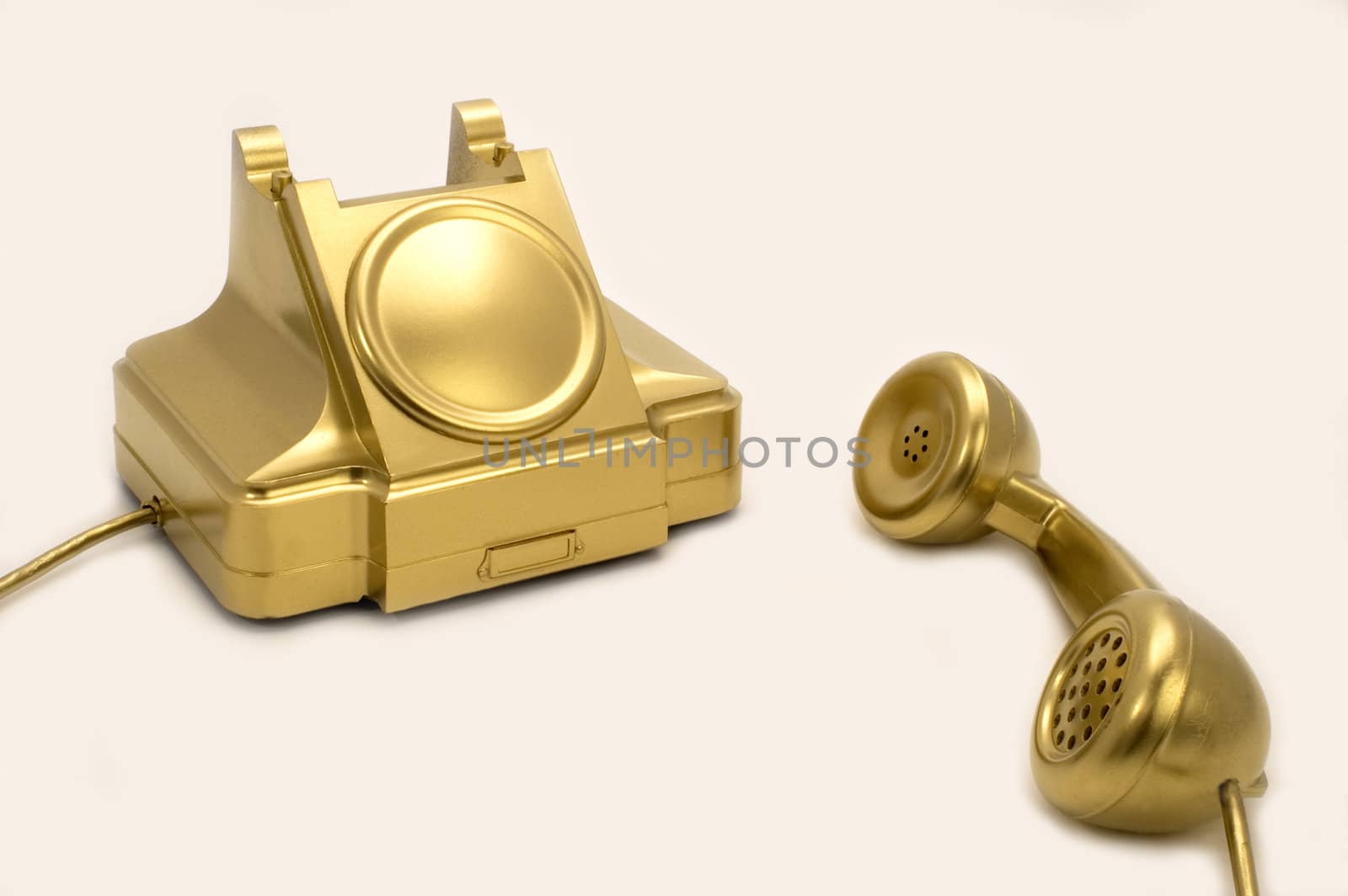 The telephone of gold colour on a white background.