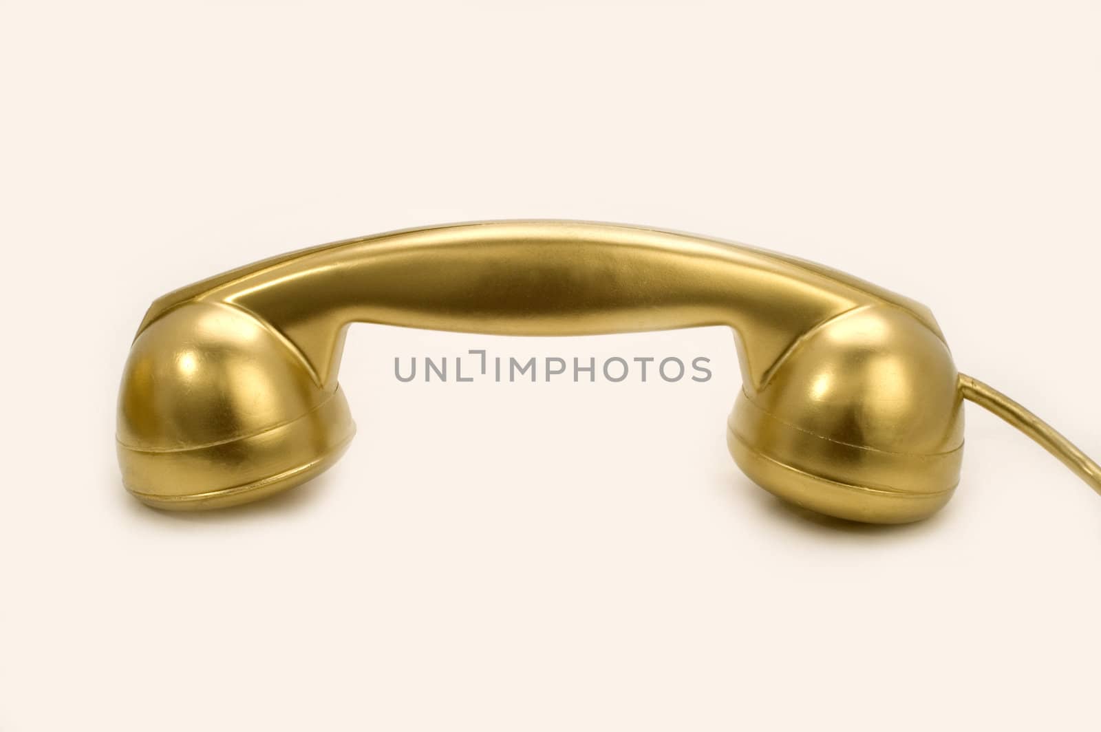 The telephone of gold colour on a white background.