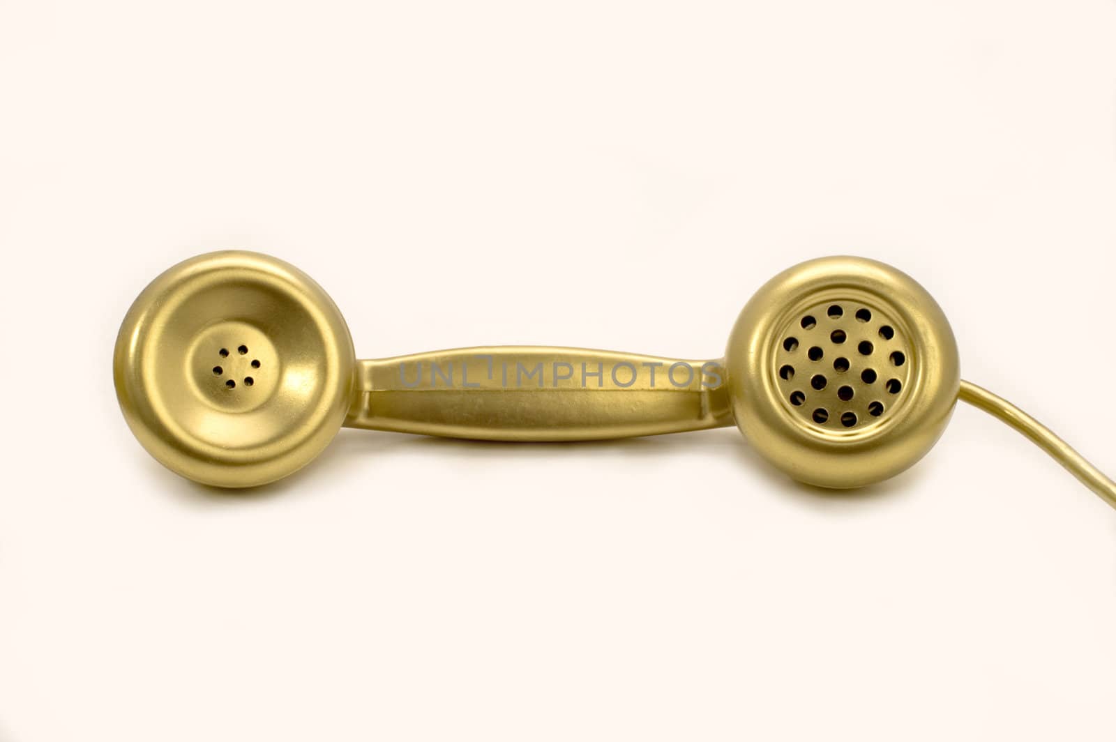 The telephone of gold colour on a white background.