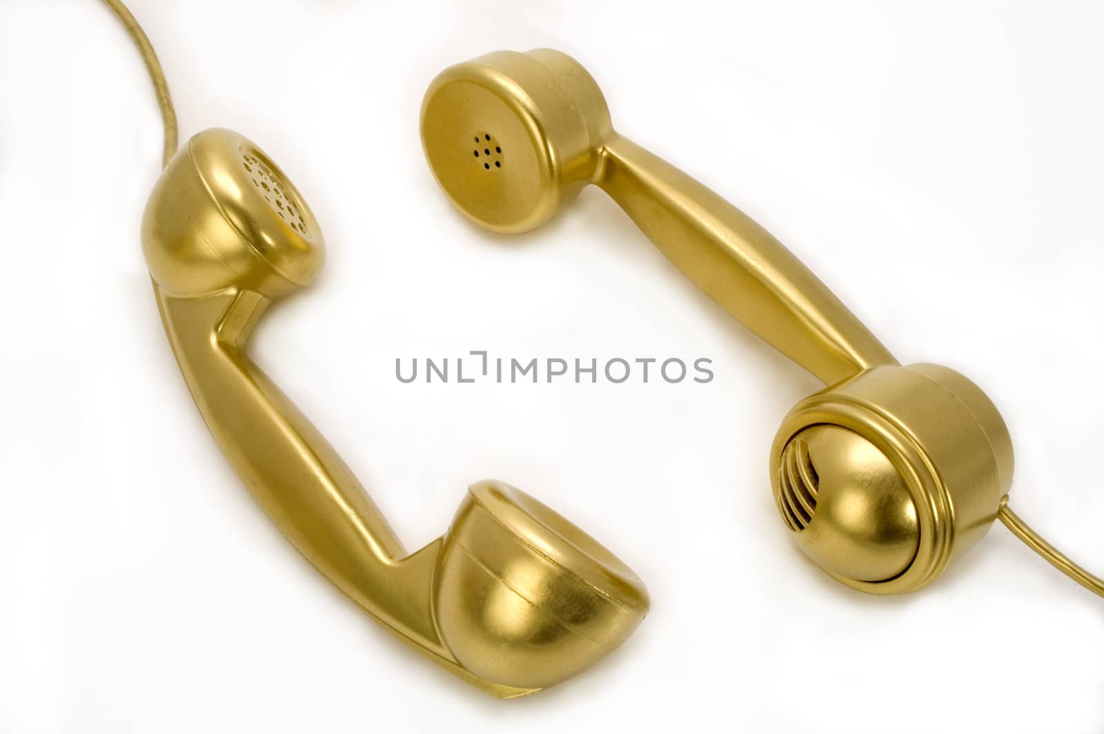 Two telephones of gold colour on a white background.