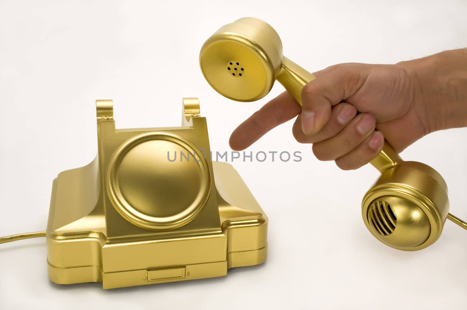 The telephone of gold colour on a white background.