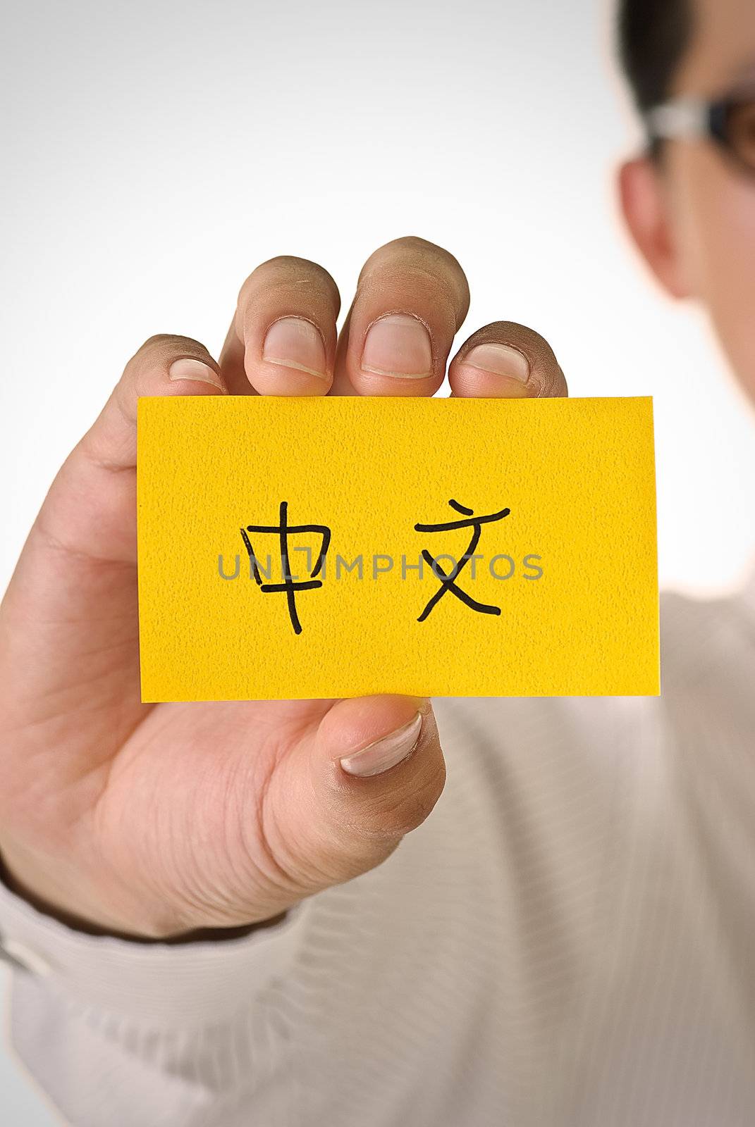Chinese words on yellow card hold by business man.