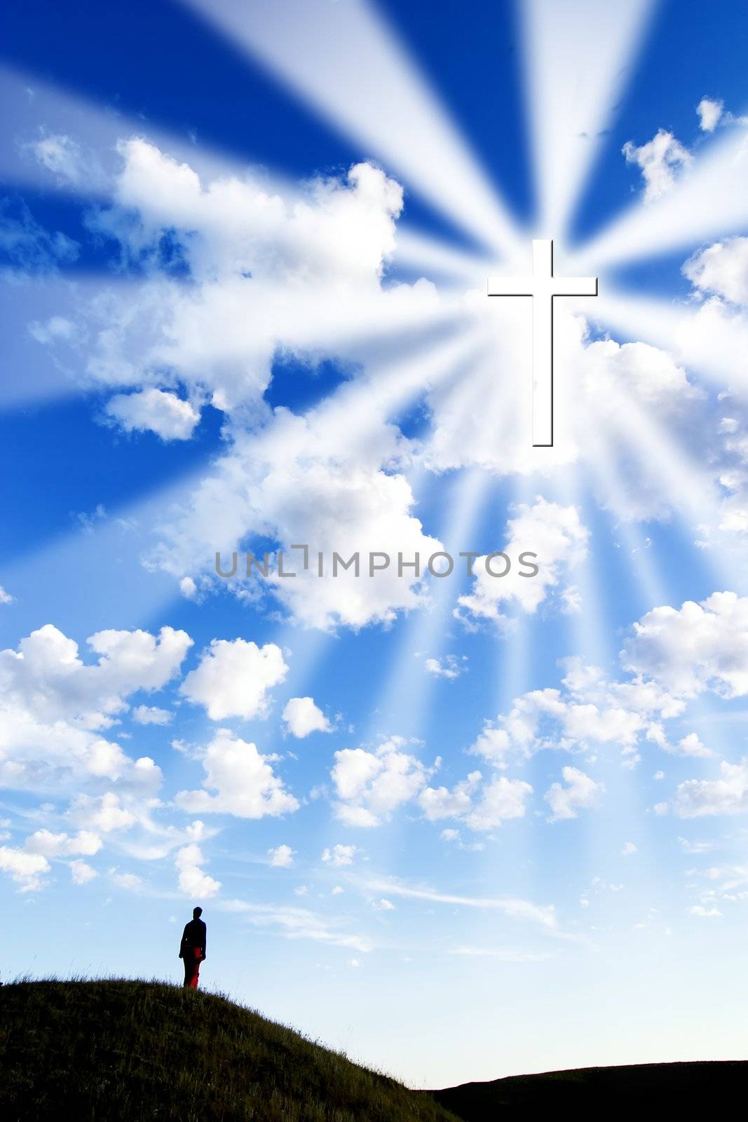 A person on a hill looking up to a glowing cross in the sky.