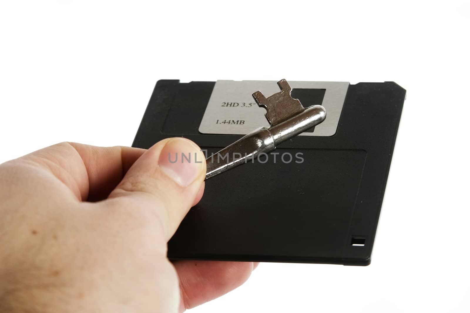 A 3 1/2" computer disk being held in the hand of a male with a skeleton key.  Isolated on white with clipping path.