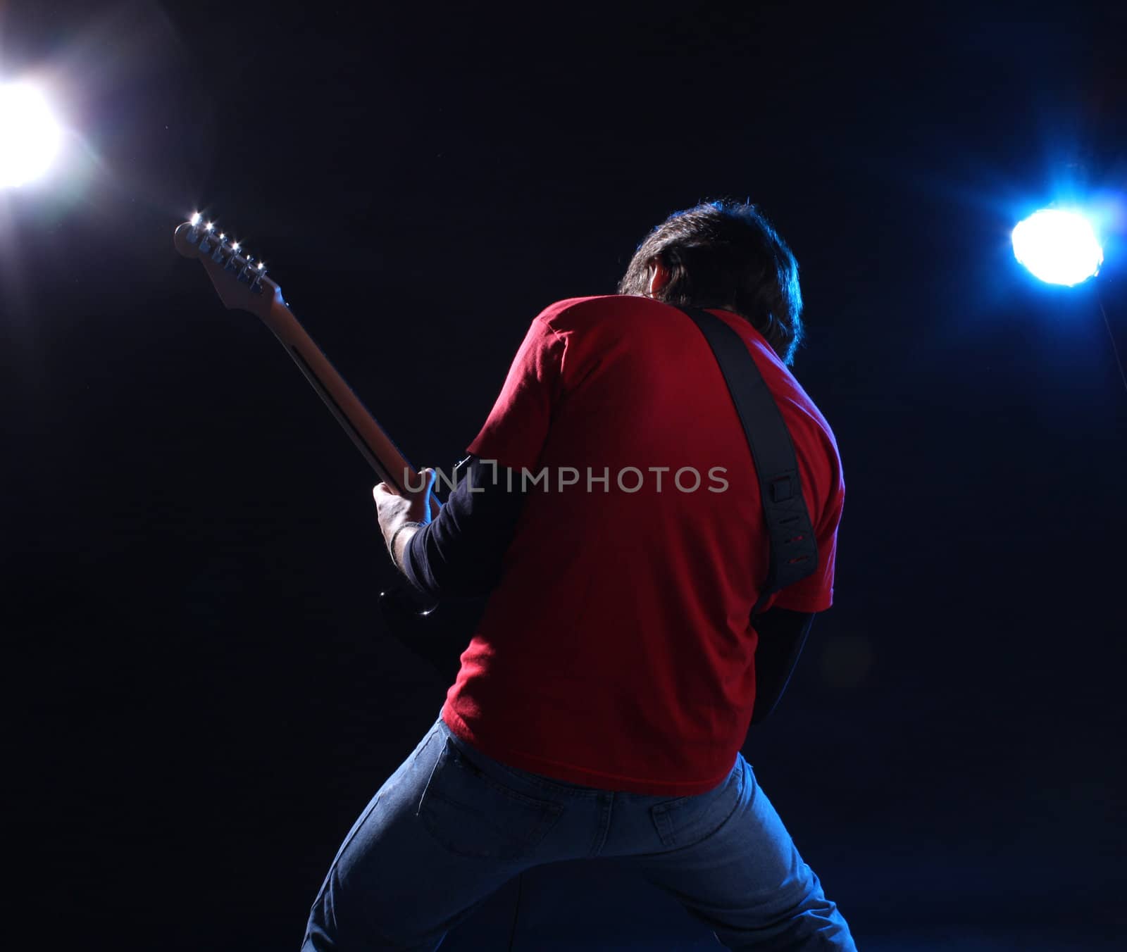 Musician playing electric guitar on stage