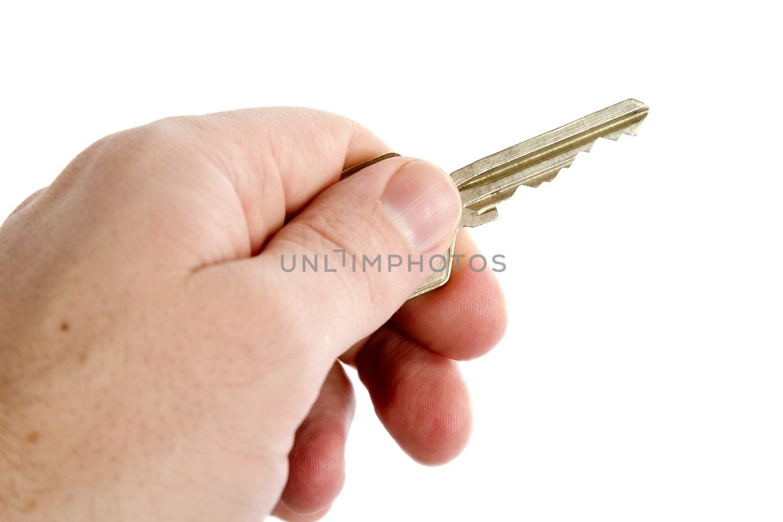 A standard key being held in a male hand.  Isolated on white with clipping path.