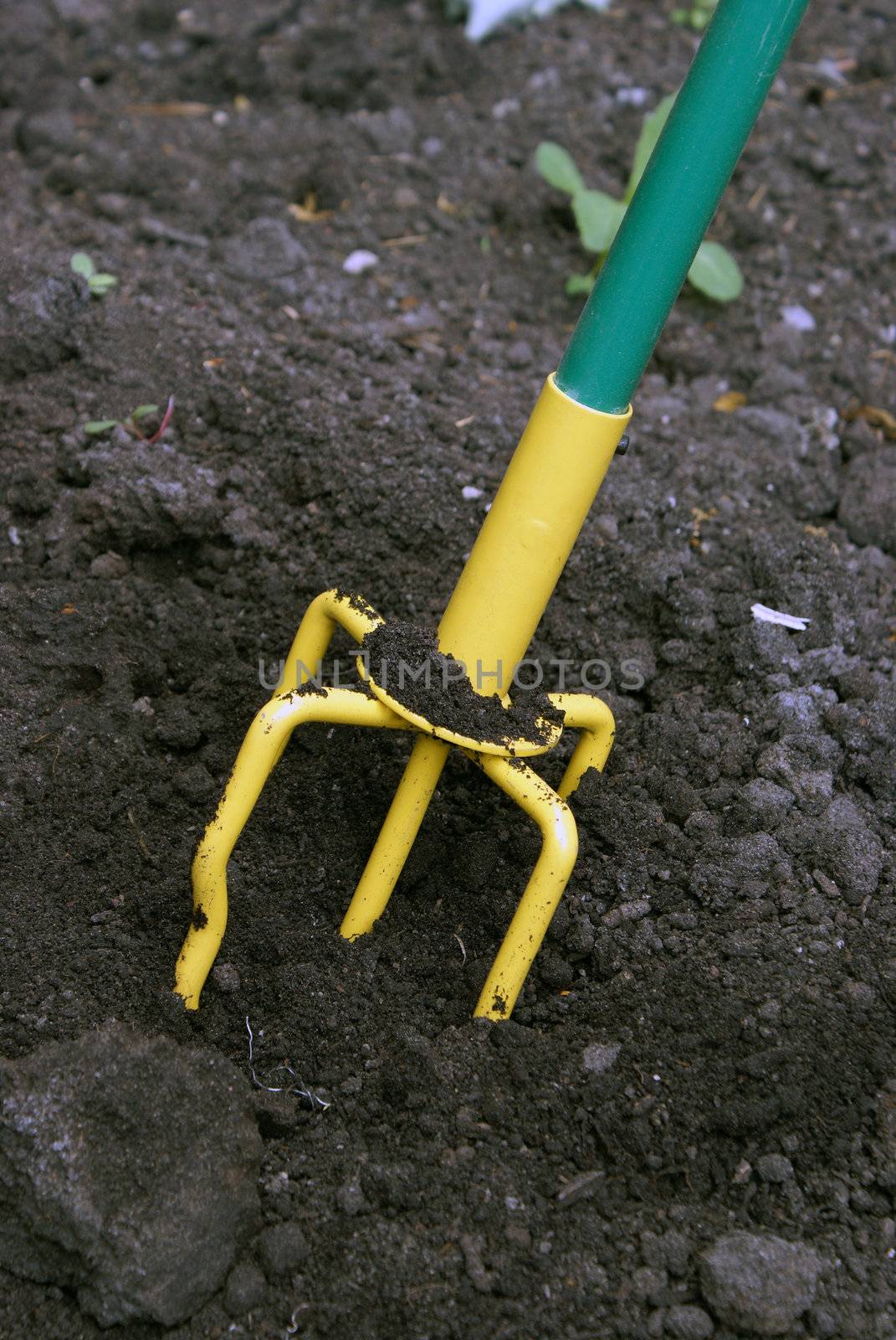 A closeup shot of a hand tiller working the dirt around.