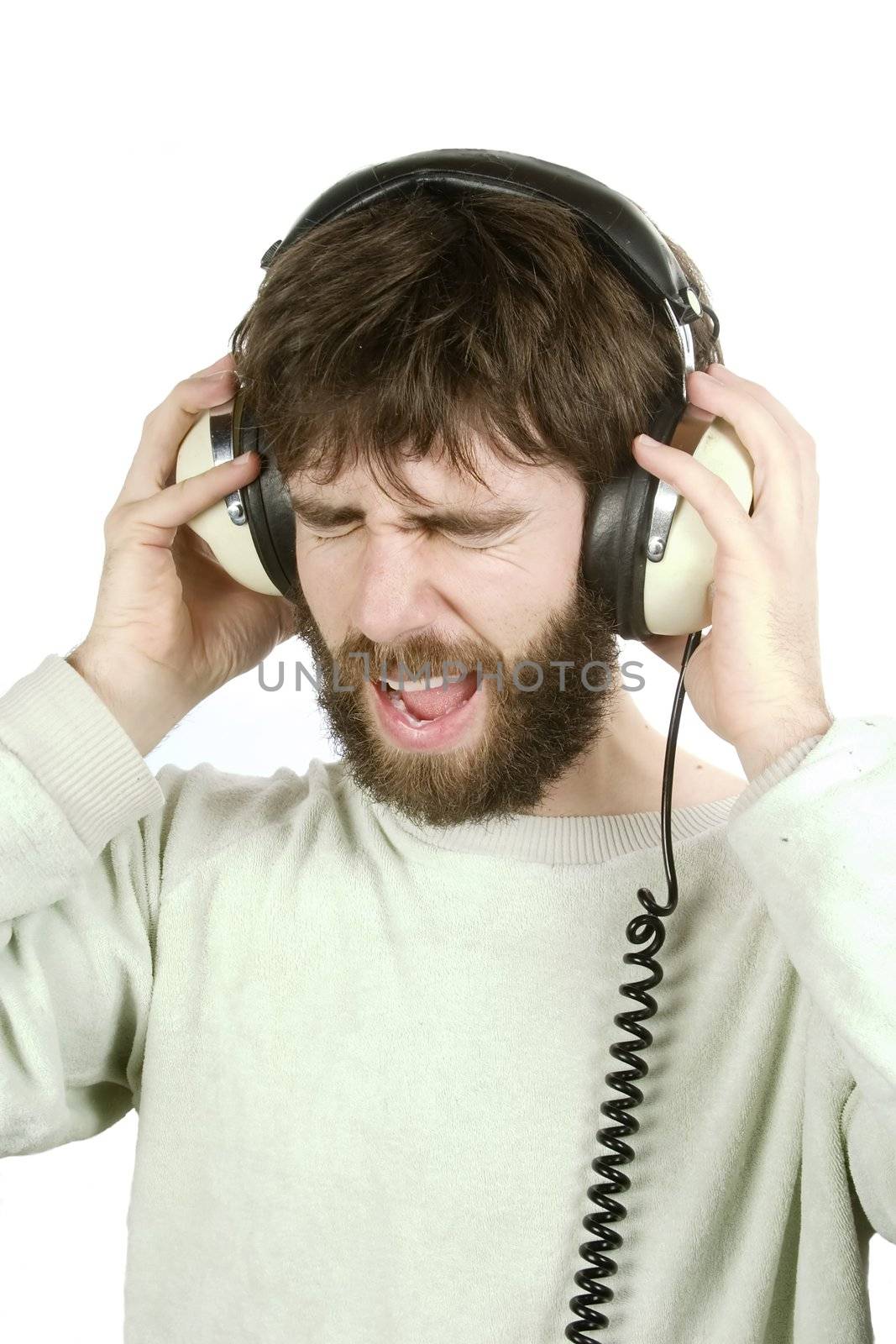 A man not enjoying what he is hearing, listening to music on large retro headphones.  Isolated on white with clipping path.