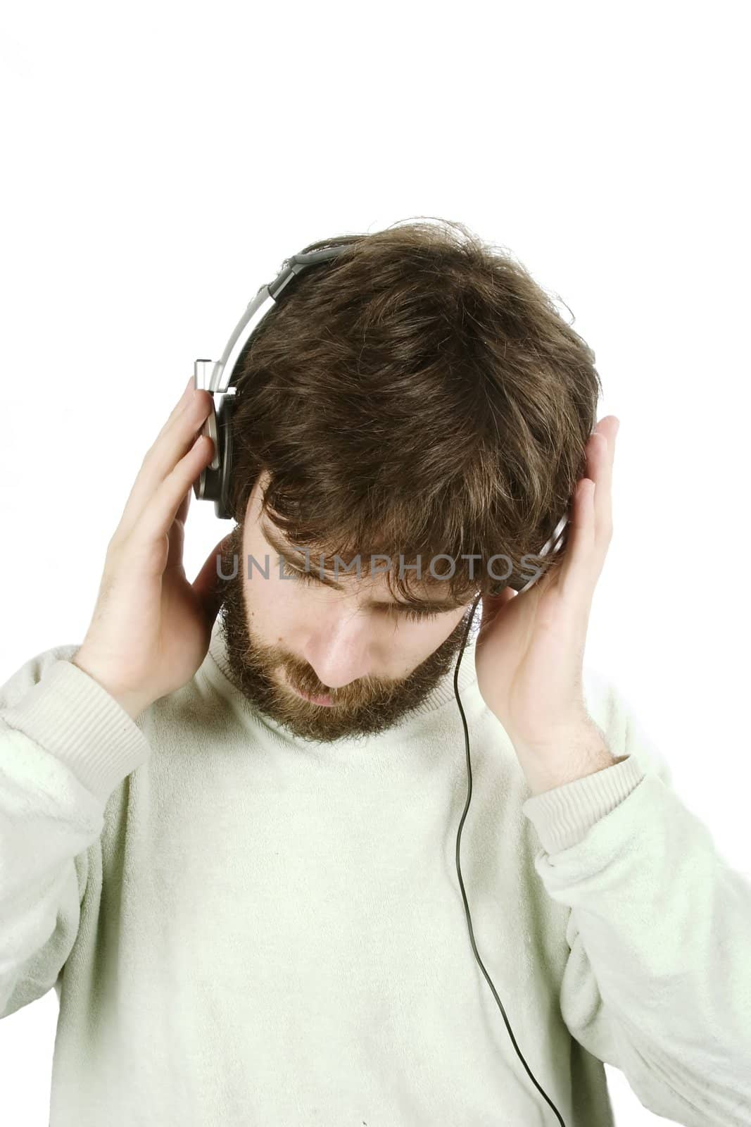 A young male with a beard listening to music on headphones. Isolated on white with clipping path.