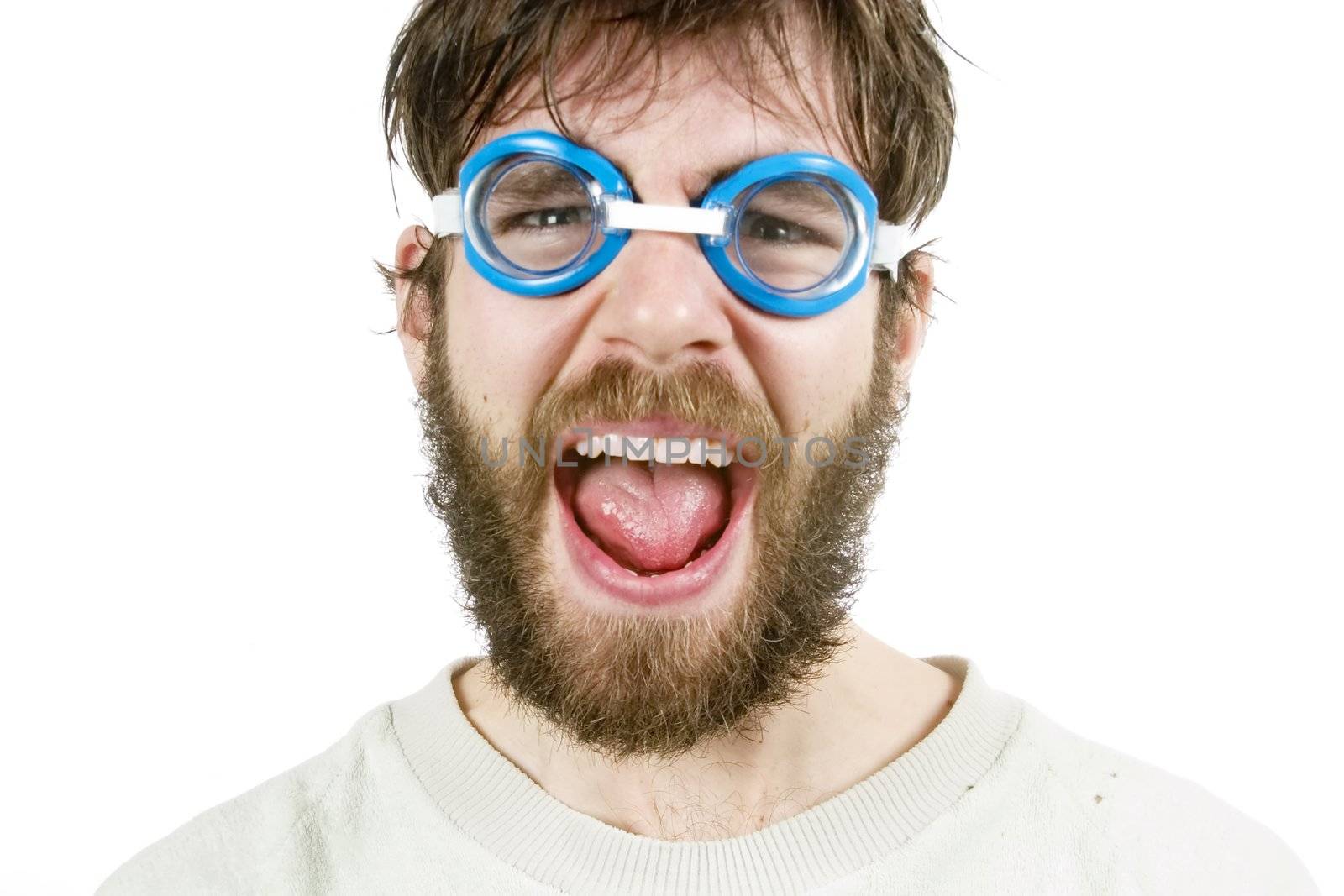 A funny looking young male with a beard and swimming goggles looking discusted or angry.