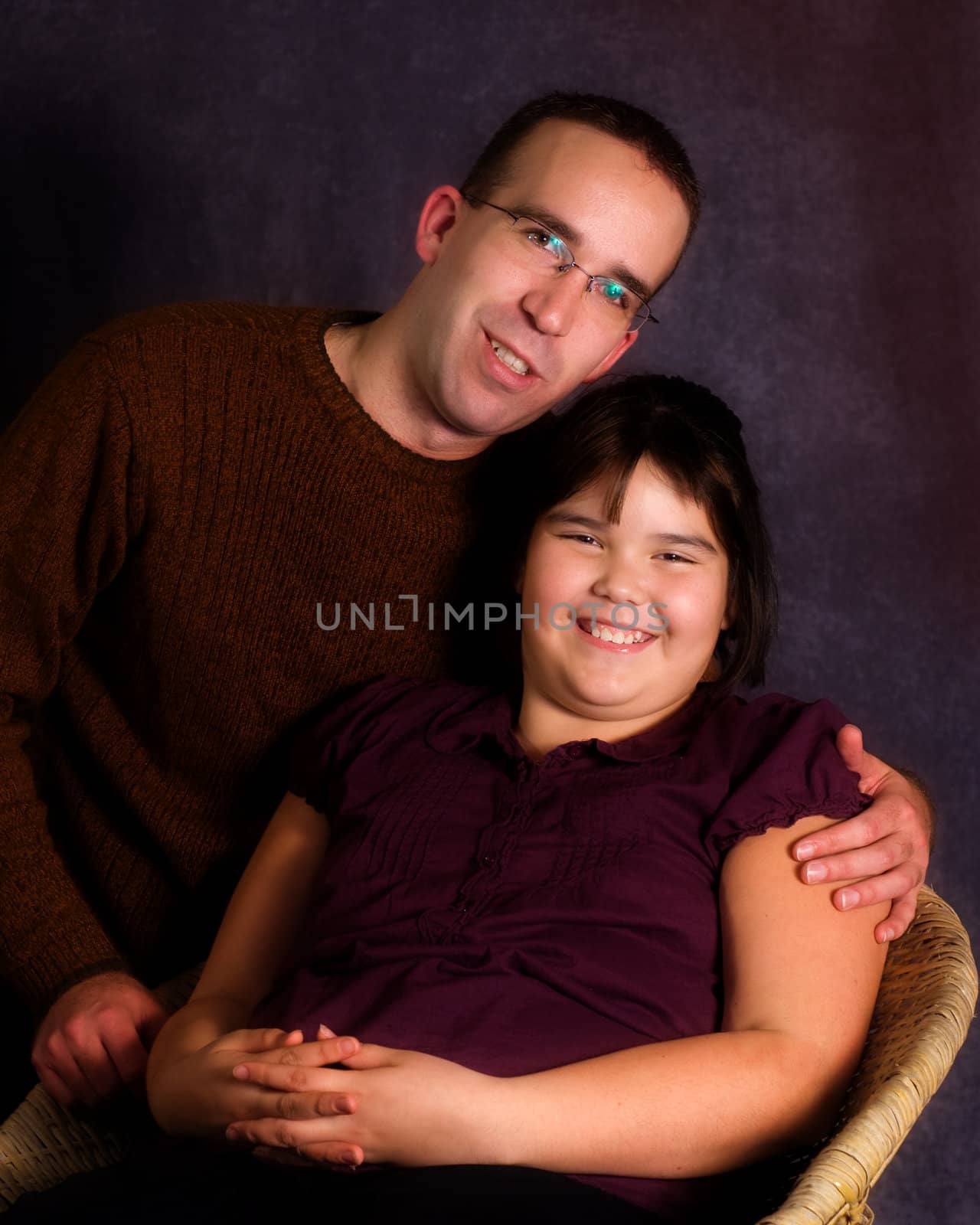 A young father and his daughter, getting their portrait done together and looking very happy
