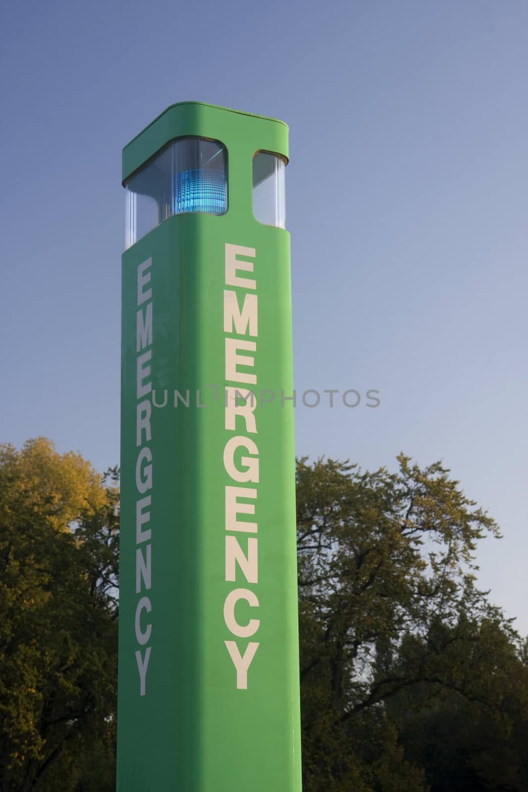 emergency calling box (upper part) at university campus against trees and sky