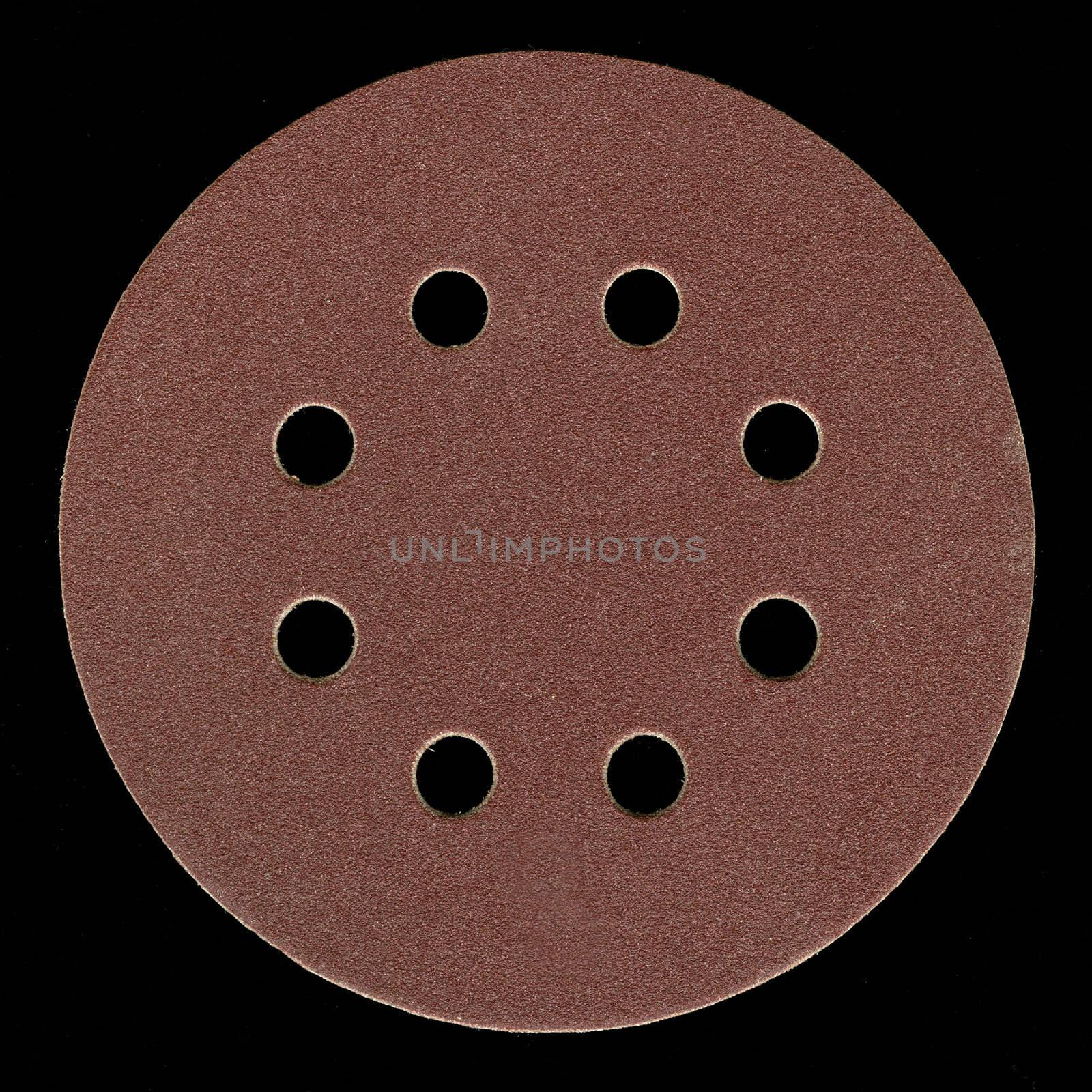 all purpose, fine grit, adhesive backed sanding disk with venting holes on black background