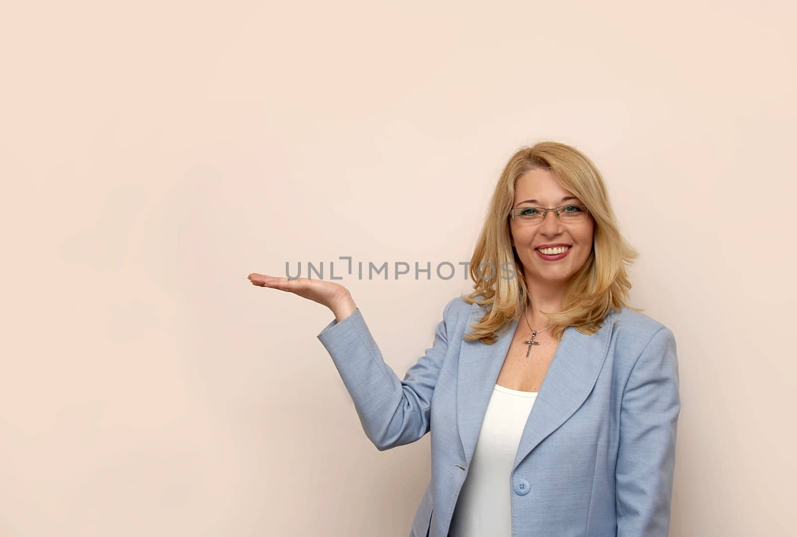 blond businesswoman in glasses showing something with right hand