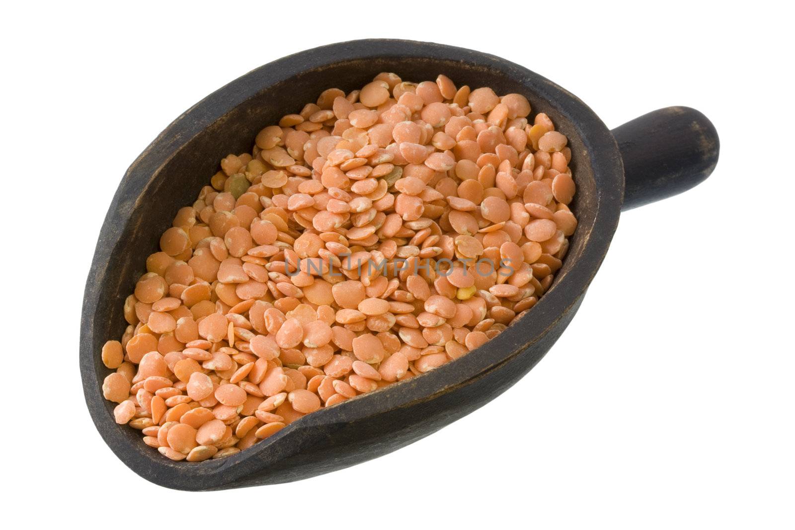 red lentils on a primitive, wooden, dark painted scoop, isolated with clipping path