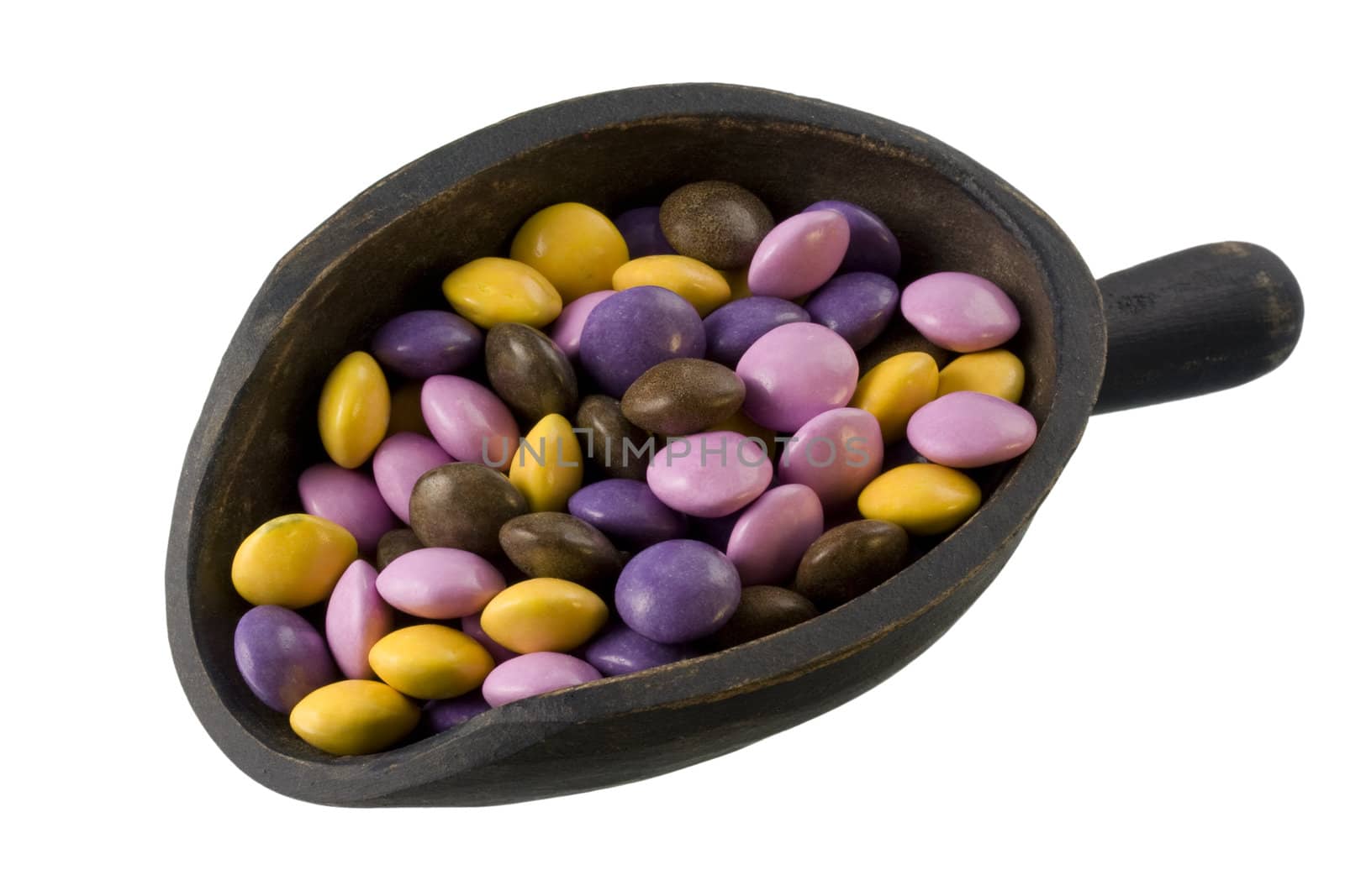 colorful coated chocolate candies on a primitive, wooden, dark painted scoop, isolated with clipping path