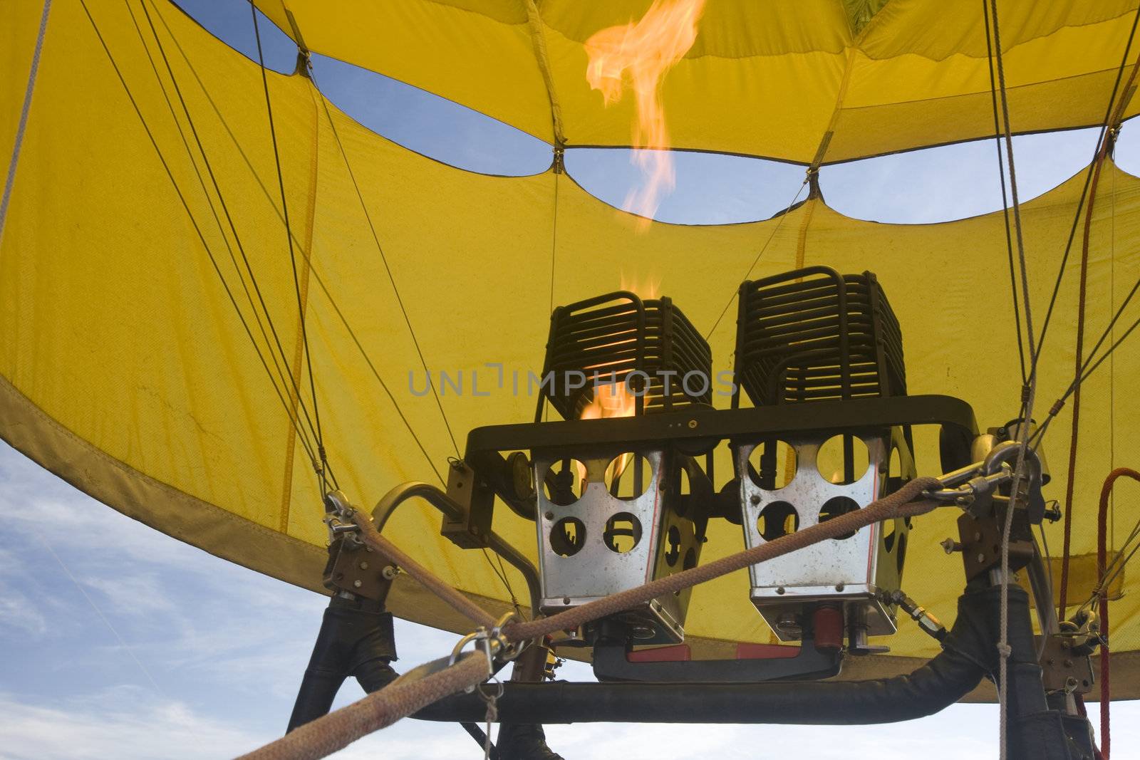propane gas burners and flame inside a yellow hot air balloon being inflated