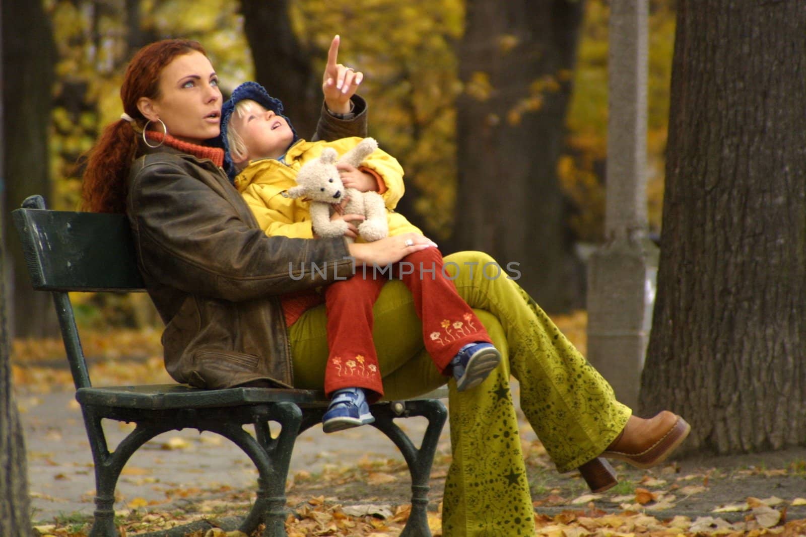 mother with her daughter rested on a bench in autumn