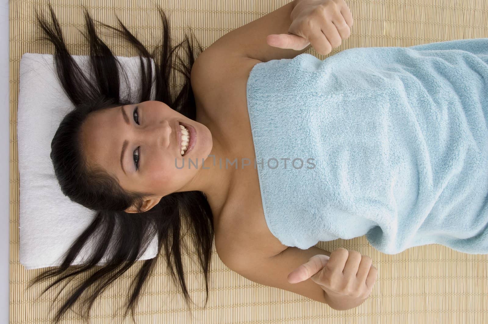 laying young woman showing thumb up by imagerymajestic