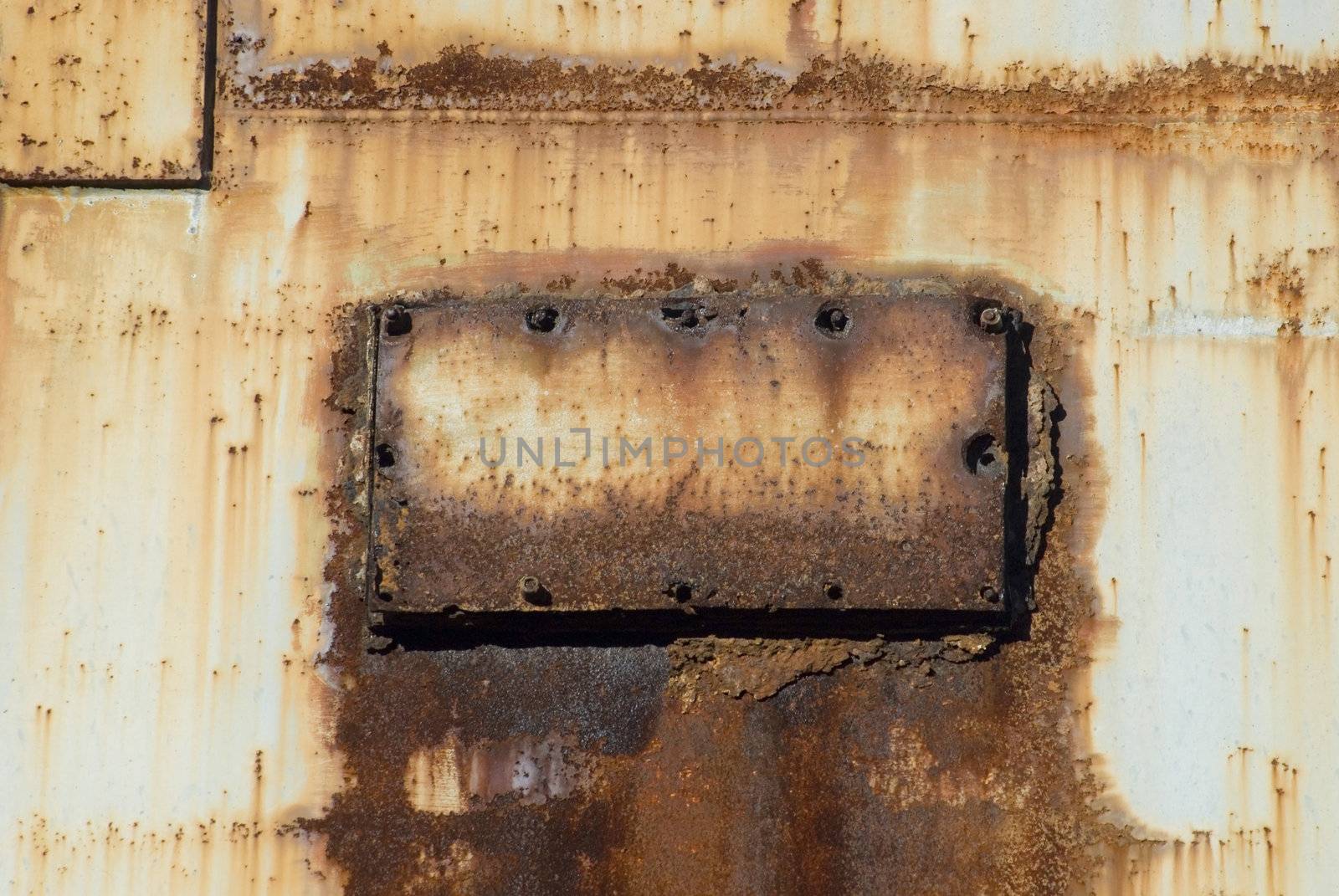 old rusting metal inspection panel with broken screws