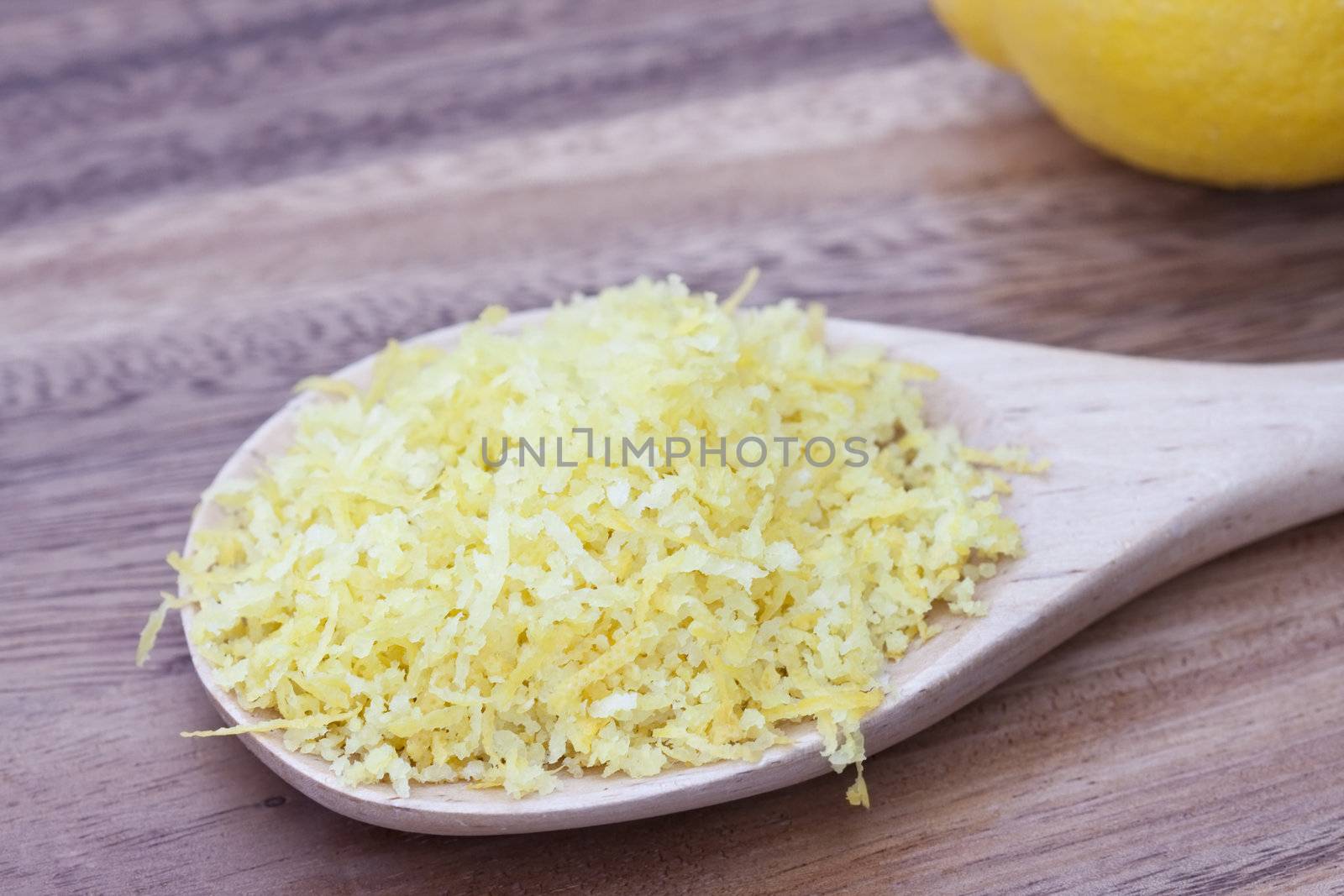 Wooden spoon filled with lemon zest. 
