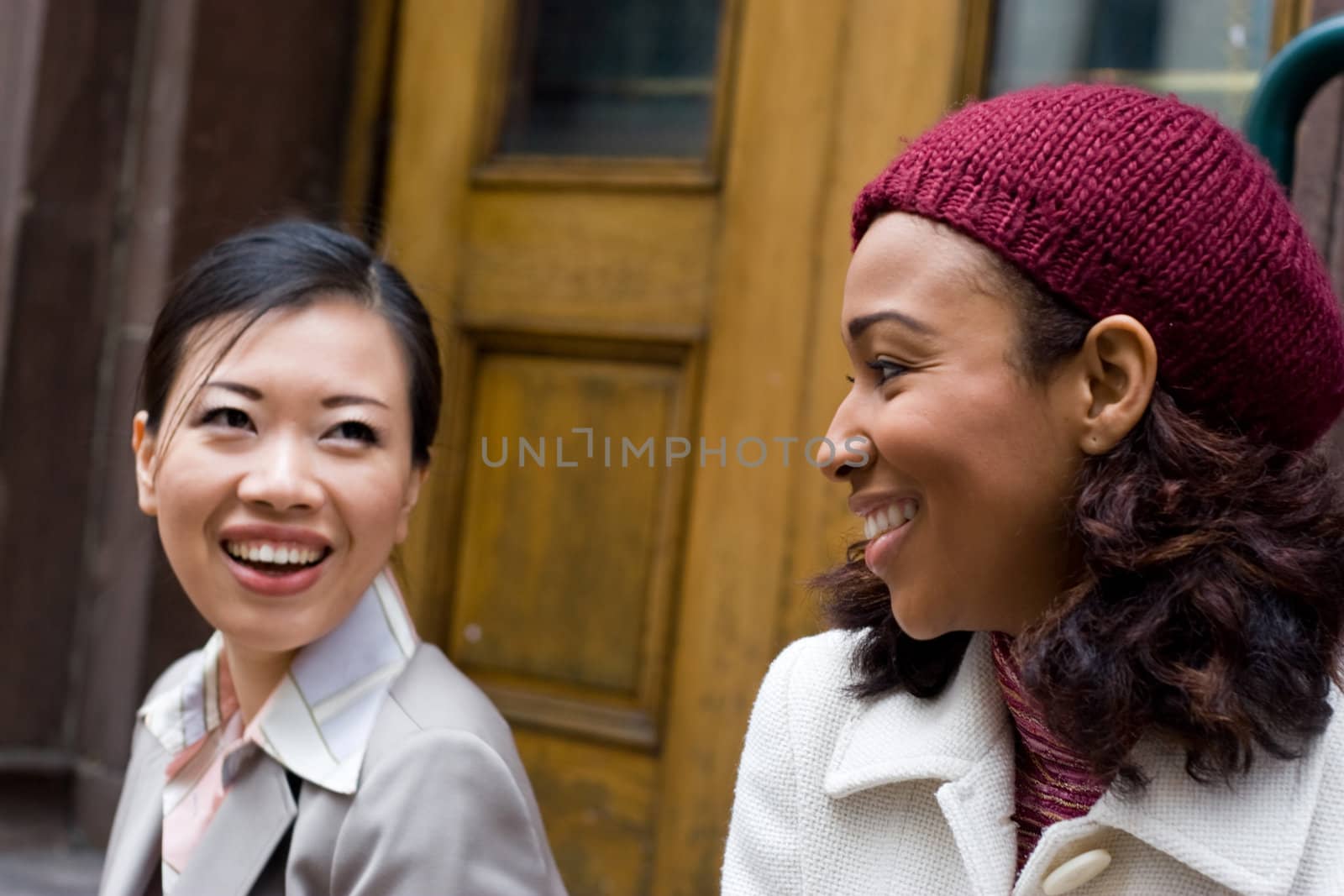 Two business women having a casual meeting or discussion in the city.  Shallow depth of field.