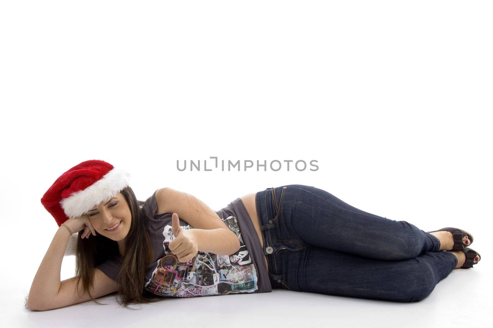 young woman in christmas hat lying on floor against white background