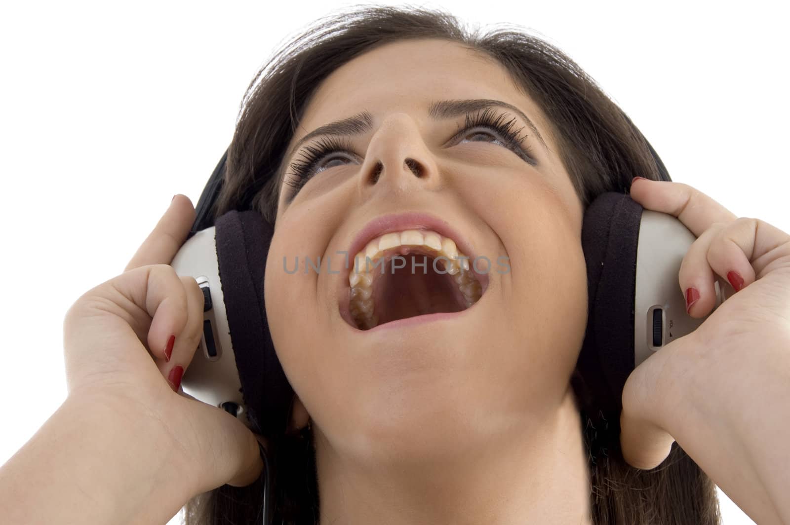 young woman listening music in headset on an isolated background