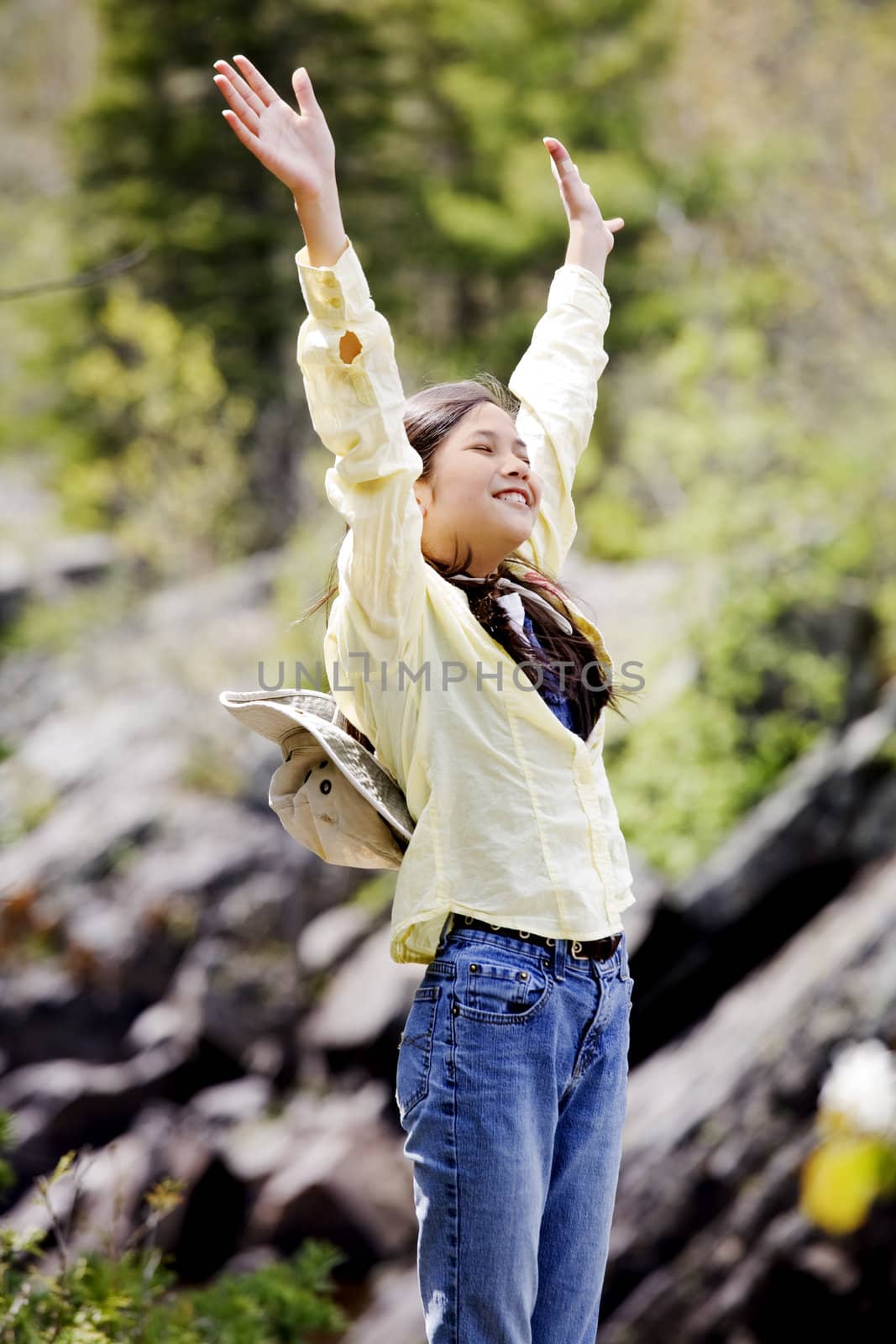 Girl raising hands in praise outdoors