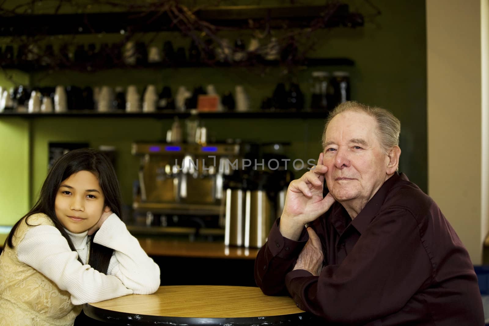Elderly man and granddaughter at coffee shop restaurant together
