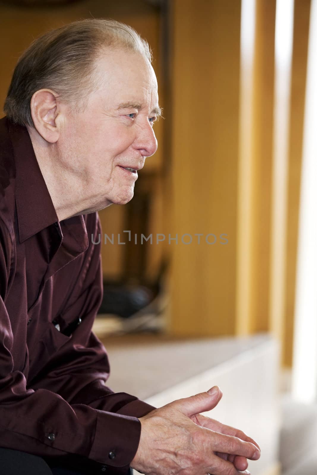 Elderly man sitting in dark church