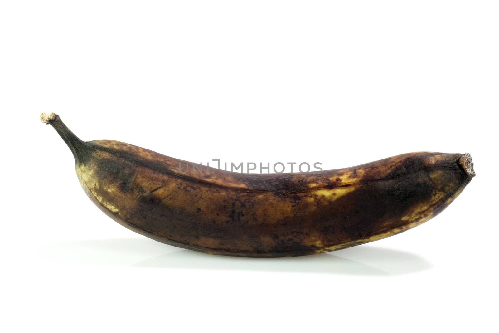 Brown rotting banana on bright background