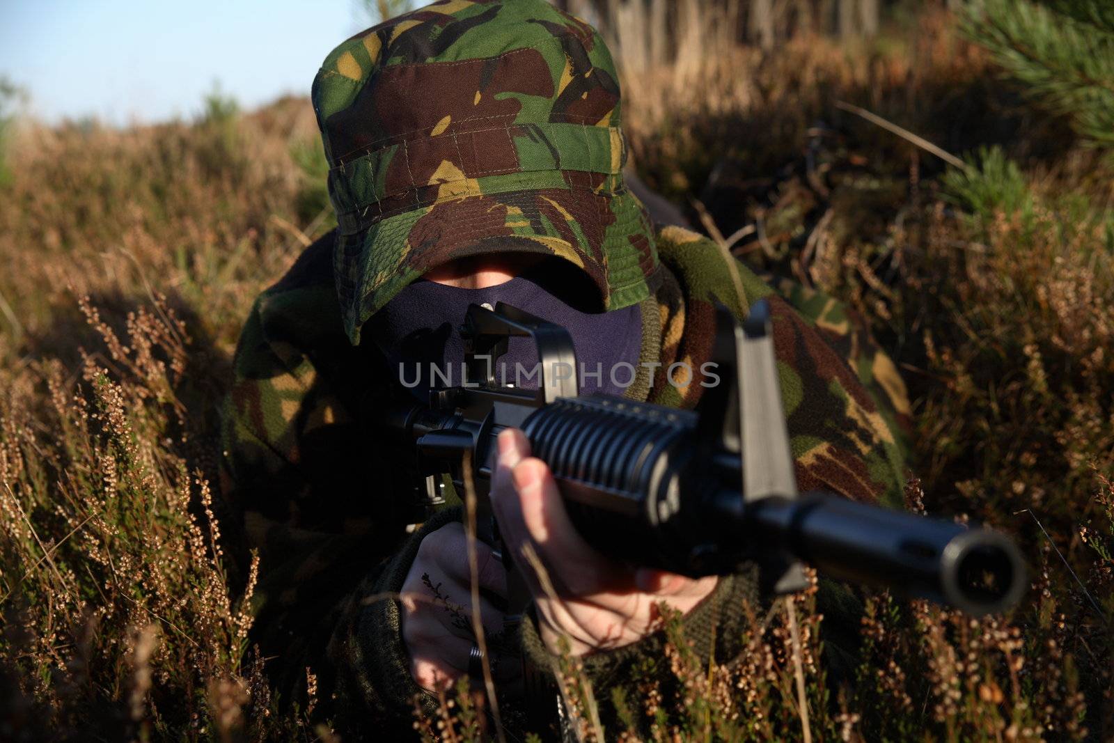 A soldier on the floor pointing his rifle forward!