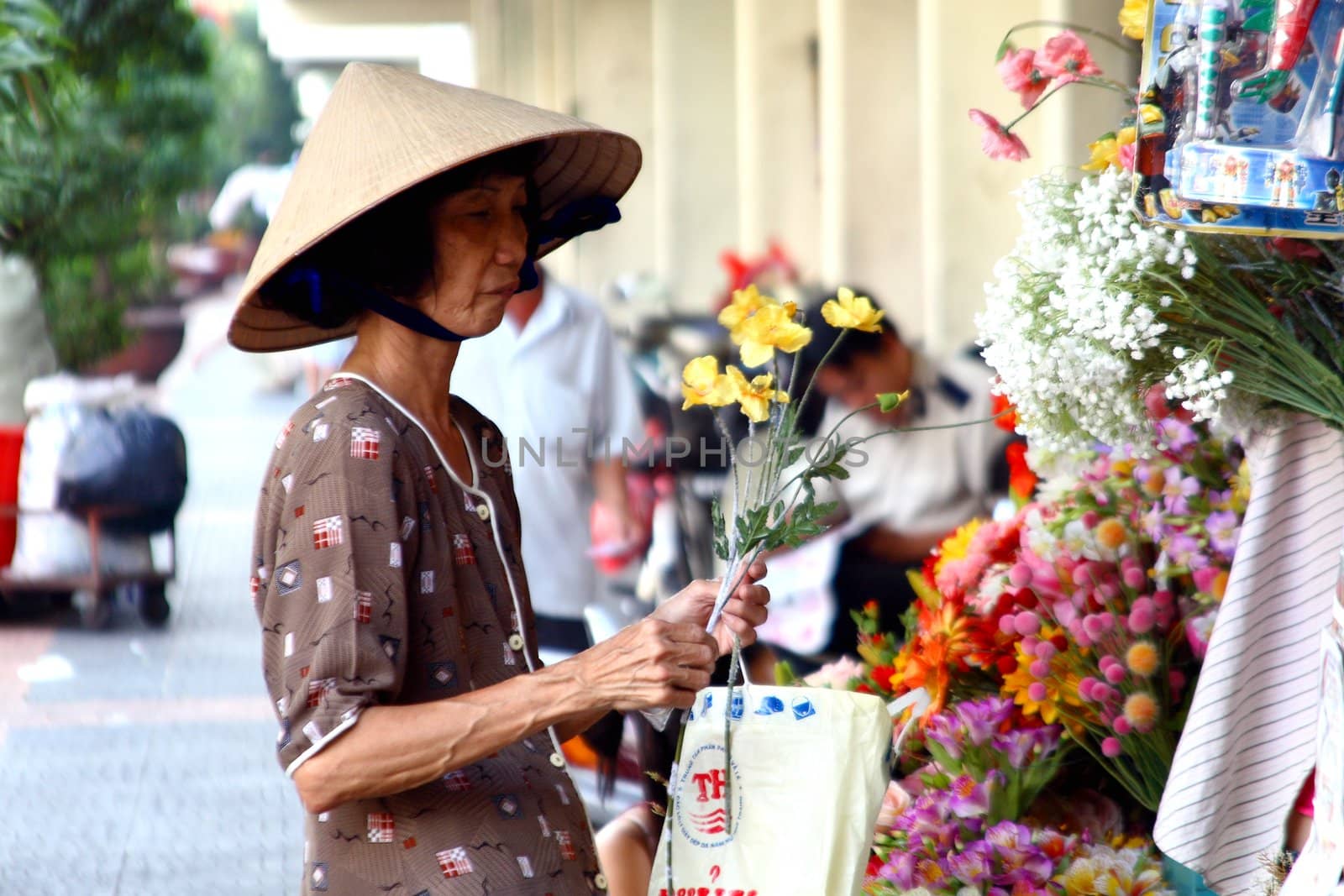 old woman with flowers - saigon street - vietnam