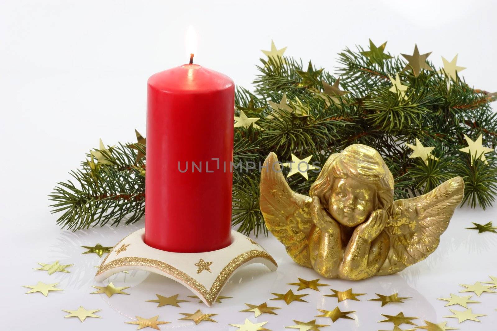 Golden angel with red candle and fir branch on light background