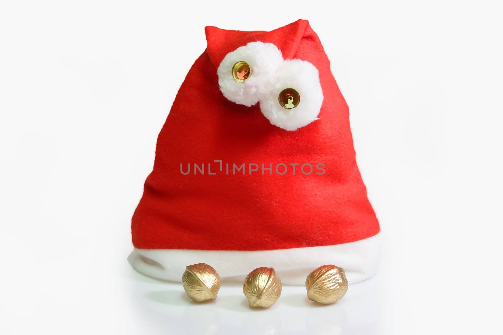 Santa hat with three golden walnuts on light background