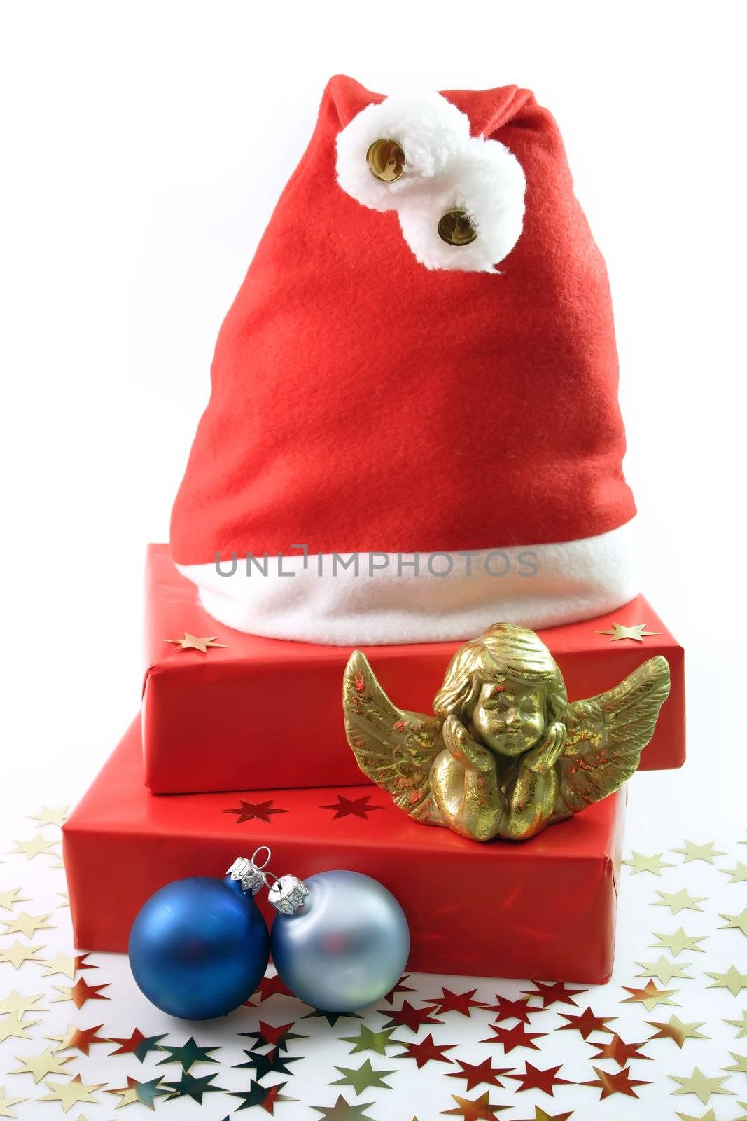 Santa Hat, red presents, golden angel figure, blue chrismas tree balls on light background