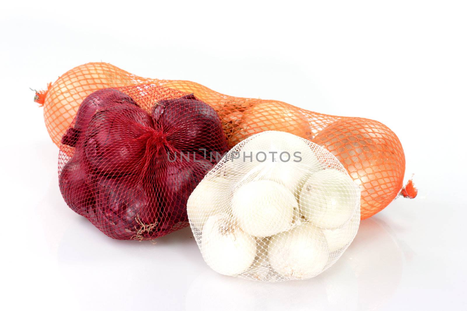 Three sorts of onions in meshes on bright background