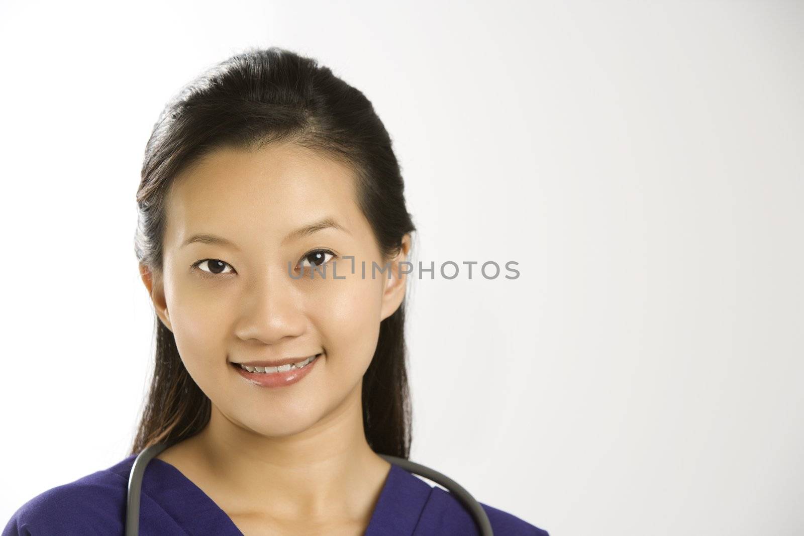 Portrait of Asian Chinese mid-adult female doctor smiling and looking at viewer.