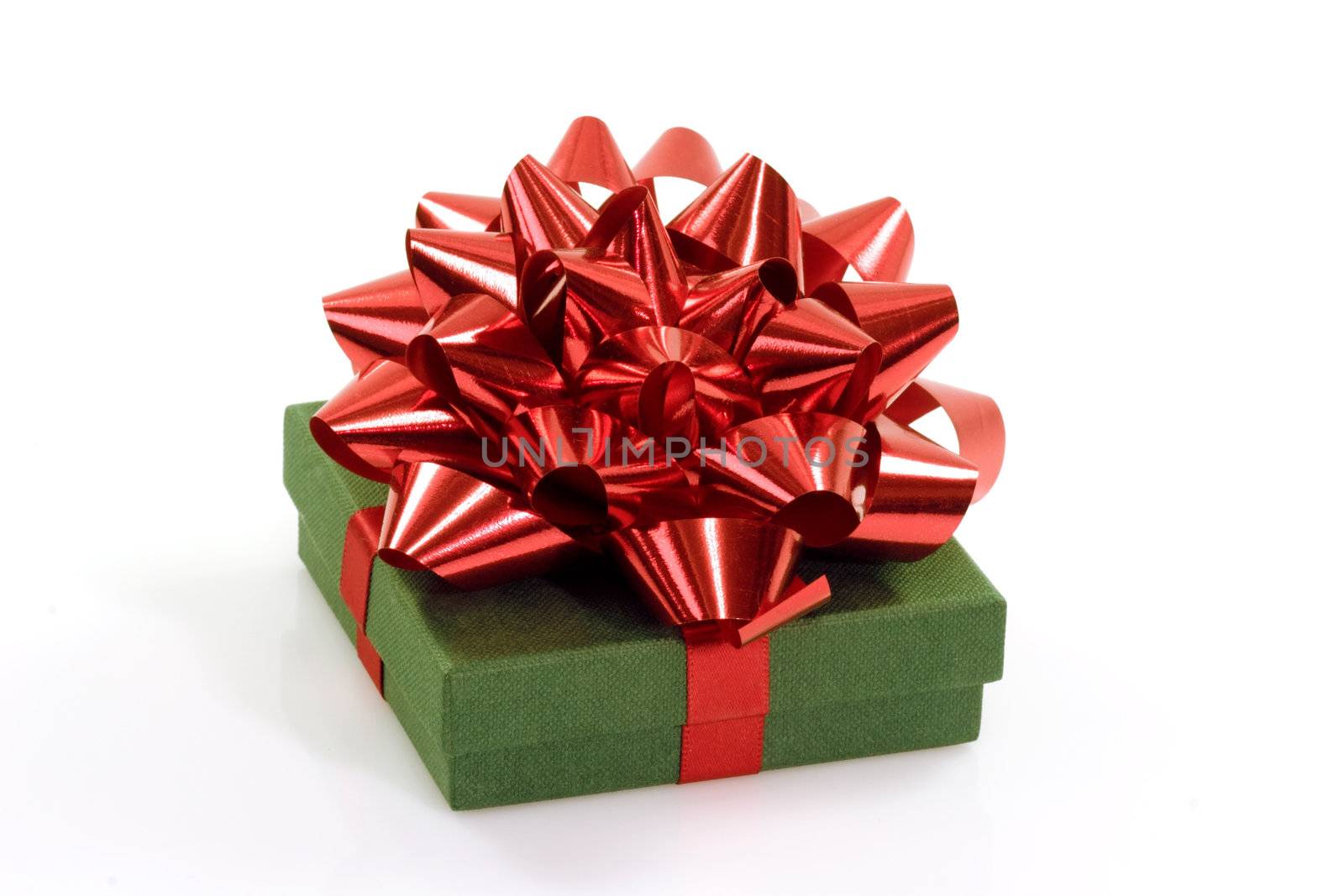 Close up of a green christmas gift with red bow on bright background