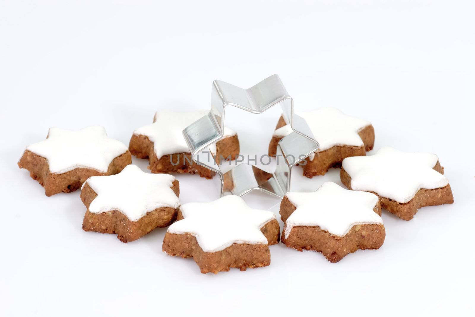 Cinnamon cookies with cookie cutter on bright background