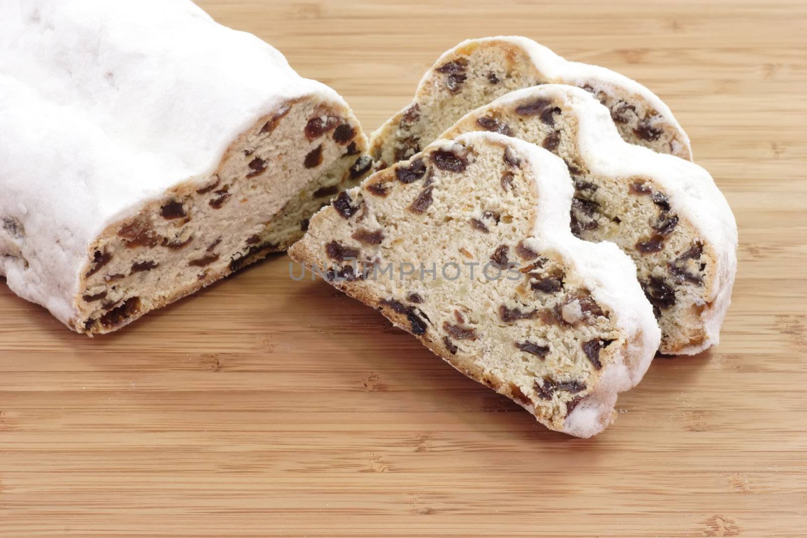 Sliced christmas stollen on a wooden kitchen board