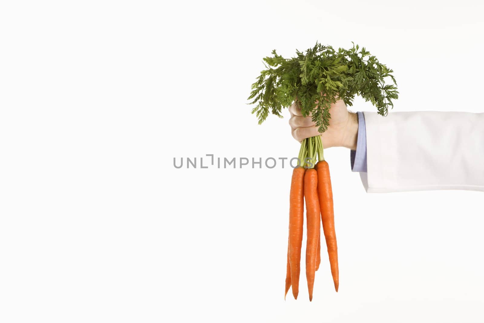 Caucasian mid adult male physician holding bunch of carrots.