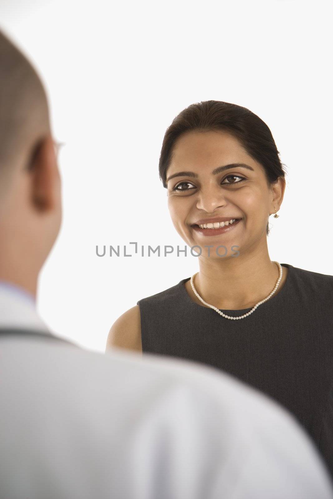 Caucasian mid adult male physician talking with Indian woman patient.