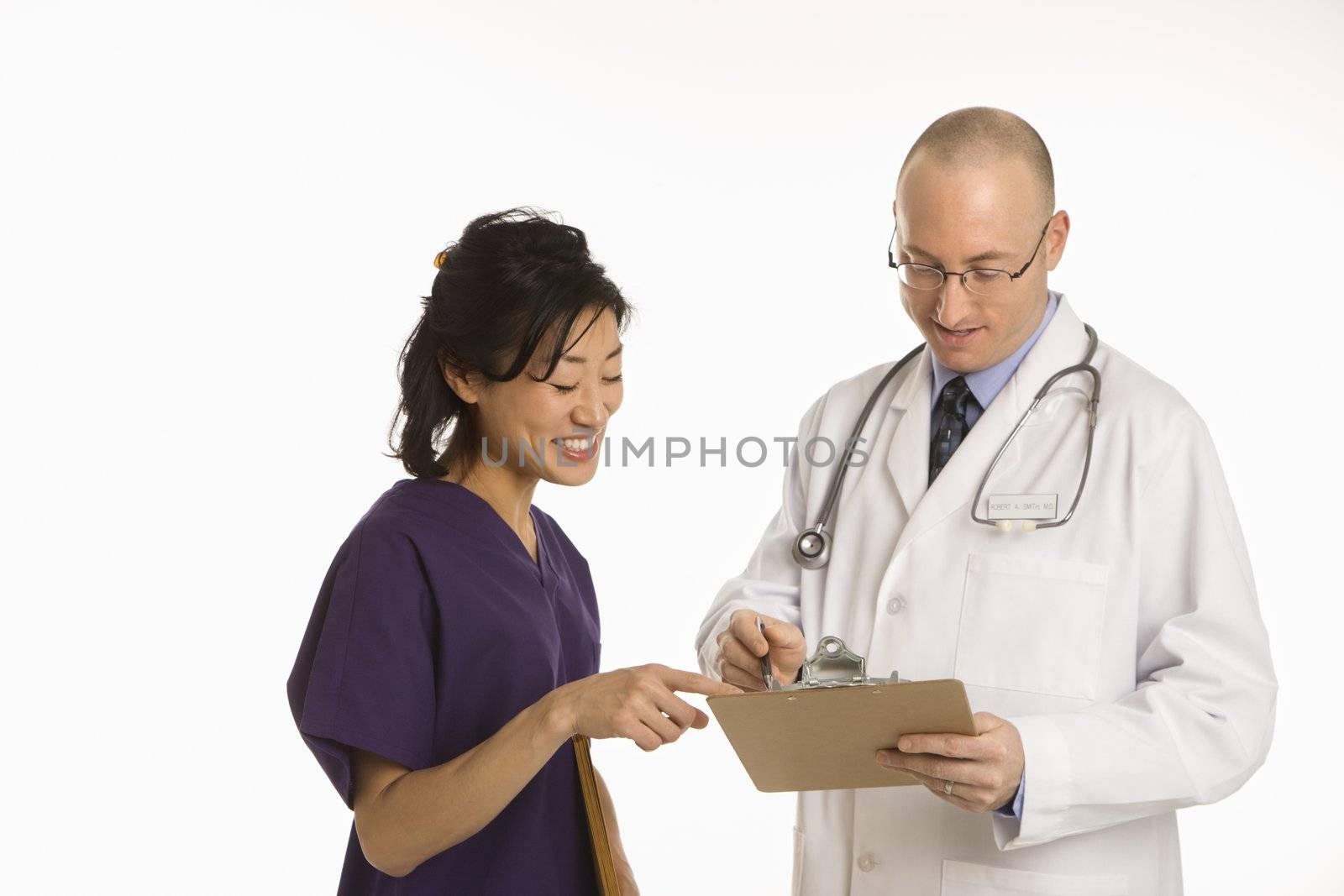 Caucasian mid adult male physician talking with Asian woman doctor.