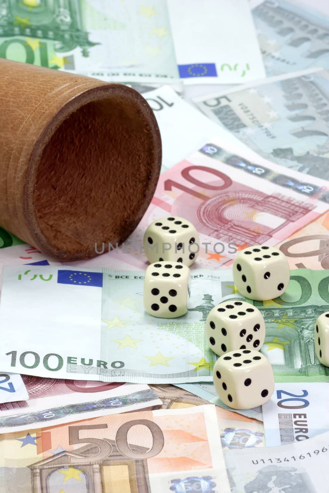 Dice shaker and dices on euro notes