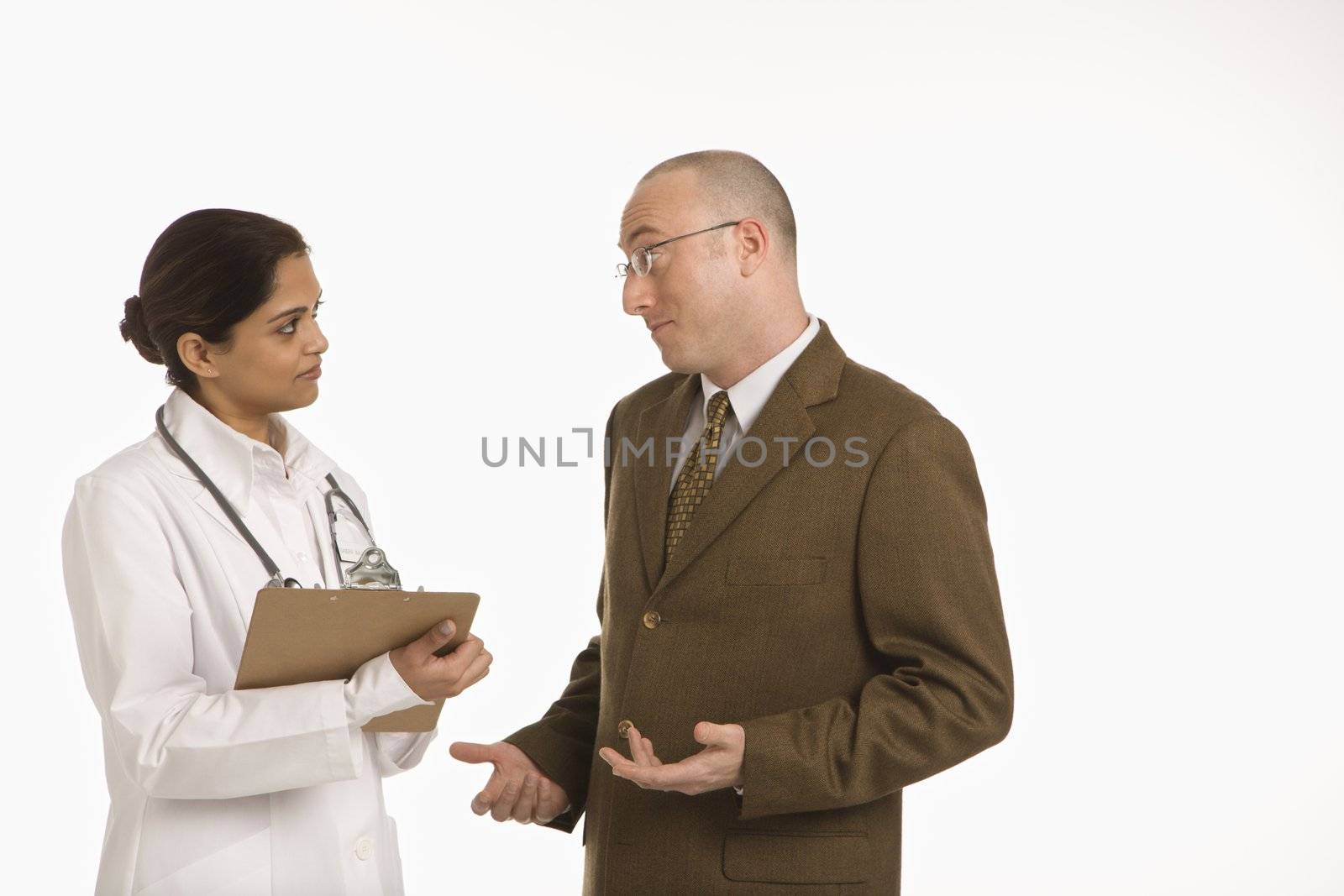 Indian mid adult woman doctor talking with man in business suit.