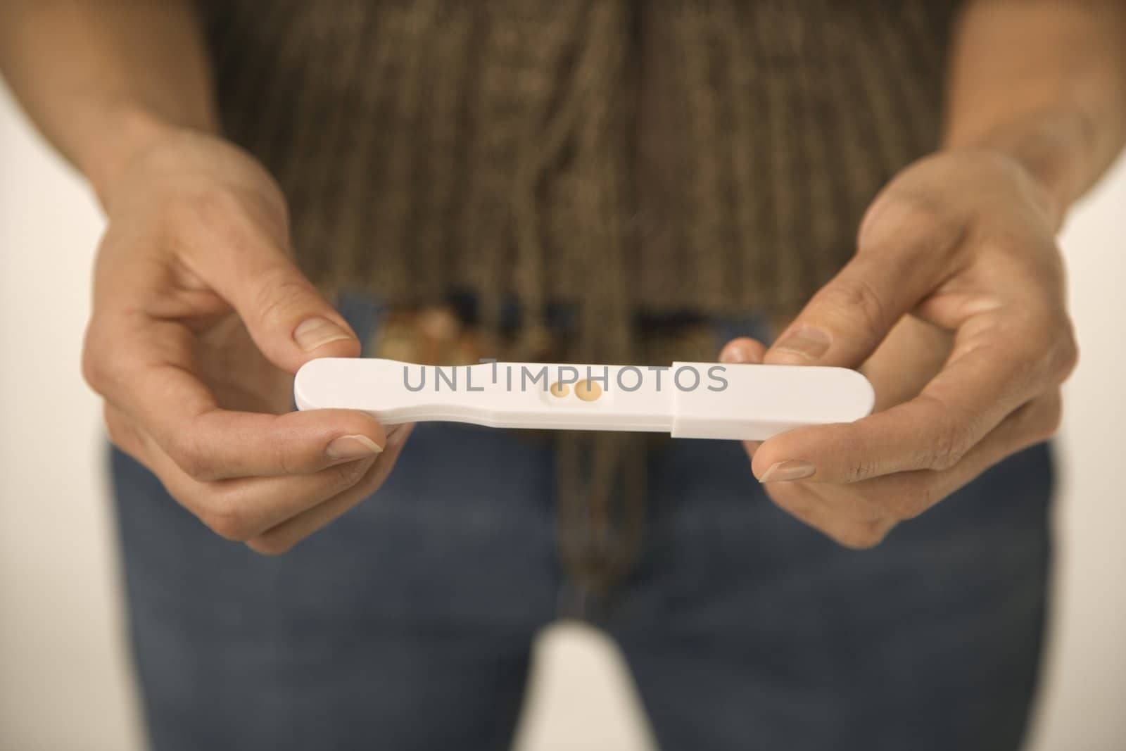Close up of Asian woman holding pregnancy test.