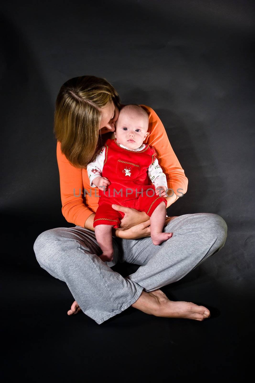 Baby caucasian girl sitting on mother's lap